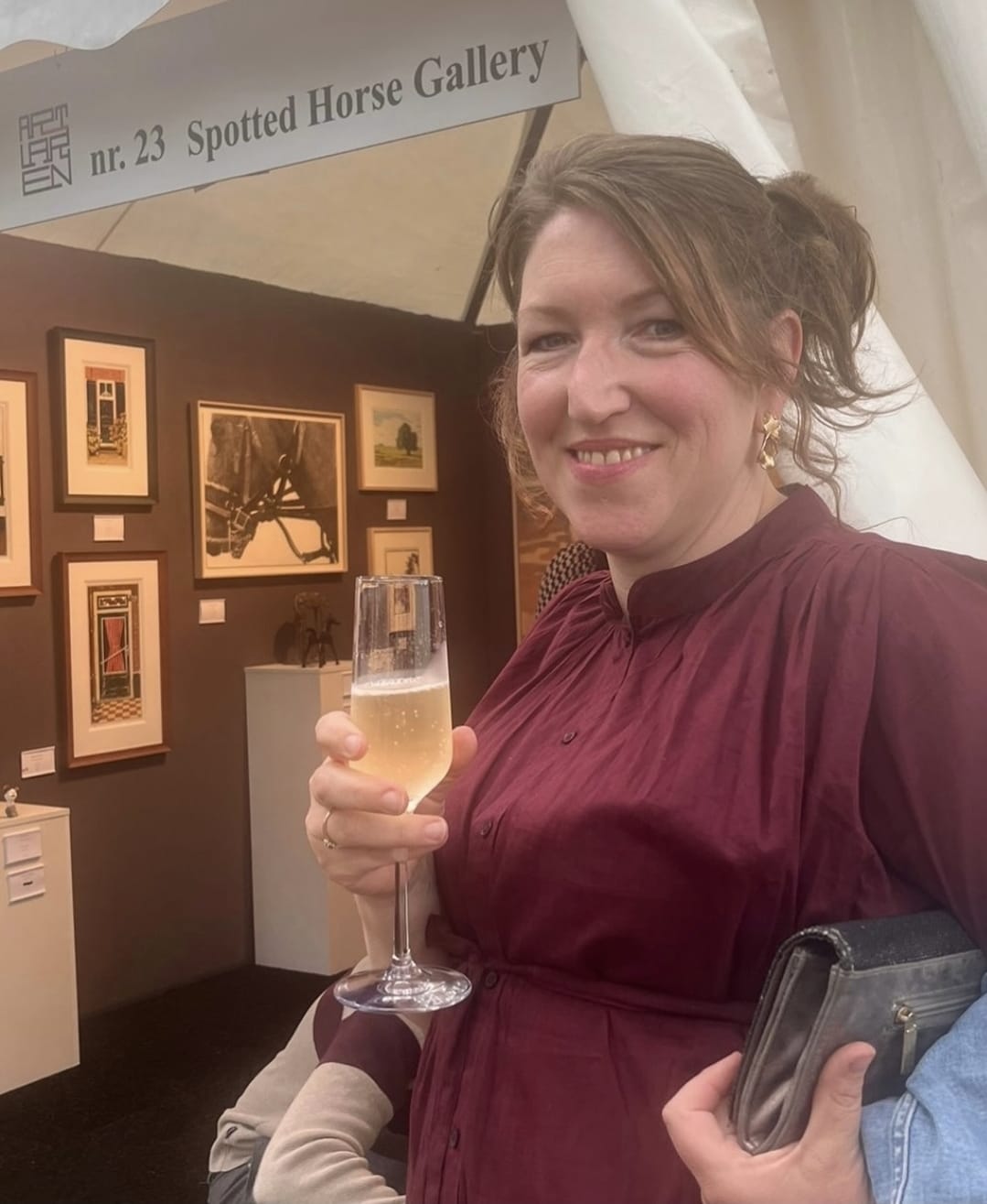 Maartje Bezemer bij haar werk op een kunstbeurs